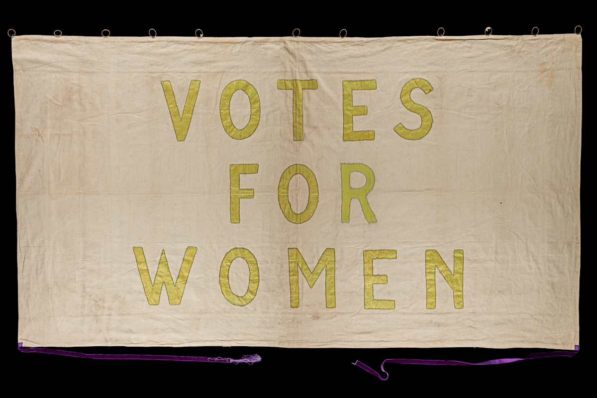 Striscione storico del movimento per il suffragio con la scritta Votes for women