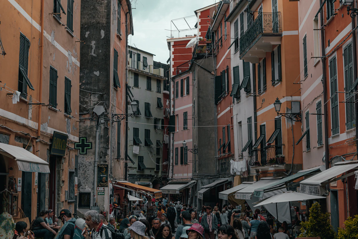 Persone che camminano in una strada stretta tra case colorate