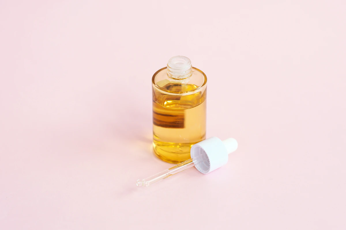 Flacone di siero per la pelle con contagocce su una superficie rosa